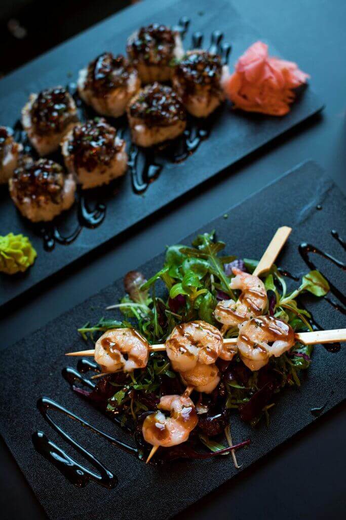Delicious grilled shrimp skewers served with mixed greens and balsamic glaze, perfect for a gourmet dining experience.